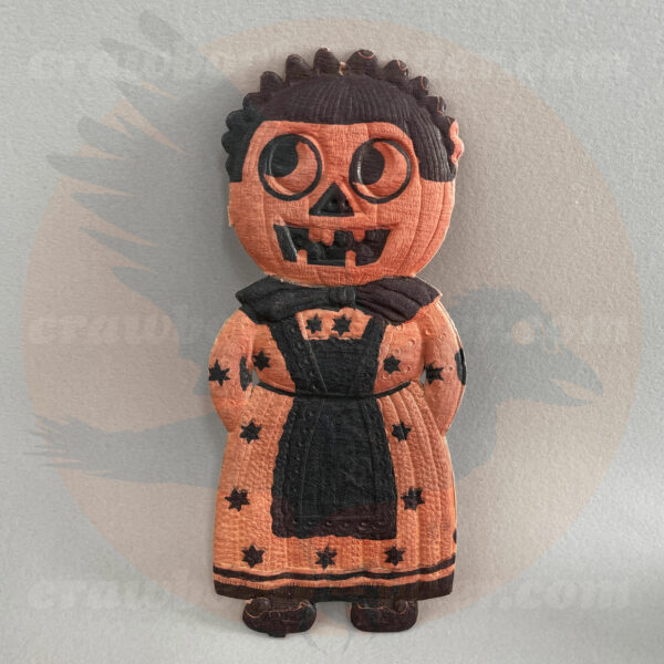 Jack O'Lantern woman with bonnet and starry dirndl - a German pressed paper diecut import of antique-vintage Halloween collectibles age, offered for trade byu Craw-Bogle Trader collection, a companion site to The Halloween Retrospect archive library. (Note buying and selling are options which may be considered upon contacting the collector of the website).