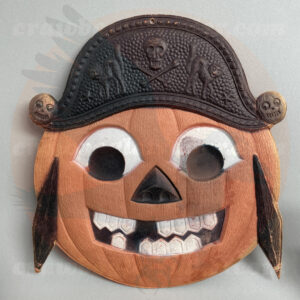 Jack O'Lantern pirate face with hat featuring skull and crossbones and two arched black cats, a German import pressed cardboard diecut vintage Halloween collectible offered online from Craw-Bogle Trader (buy-sell-trade) collector, a companion site to The Halloween Retrospect archive library.