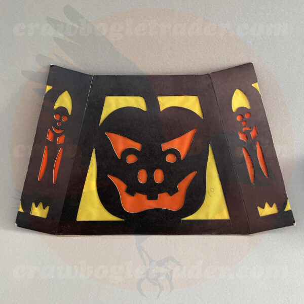 Side one of orange, yellow, and black diecut shade is a vintage Halloween collectible created by Beistle to glow-in-the-dark with light placed inside. The unusual item is featured in The Halloween Retrospects full-color guidebook of vintage collectibles Halloween Artifacts, Volume 1: Lighting. The item itself is available for-trade from Craw-Bogle Trader (while buying and selling of vintage Halloween collections is also considered and please contact the online shop for details).