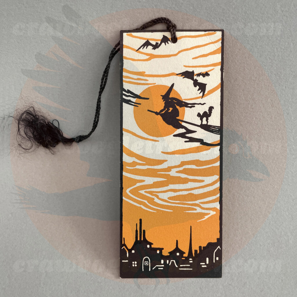 Tally card with witch flying on broom with her black cat and bats in air over a cityscape- a diecut paper vintage Halloween collectible offered by trade/buy/sell Craw-Bogle Trader collector, a companion site to The Halloween Retrospect archive library.