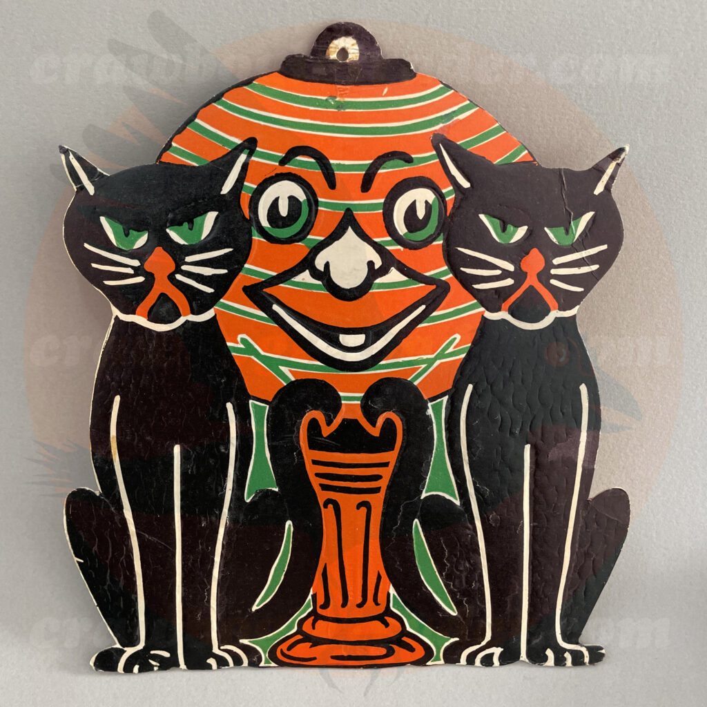 Two black cats by a lantern or orange green stripes with a face - a Beistle embossed diecut paper vintage Halloween collectible offered by trade/buy/sell Craw-Bogle Trader collector, a companion site to The Halloween Retrospect archive library.